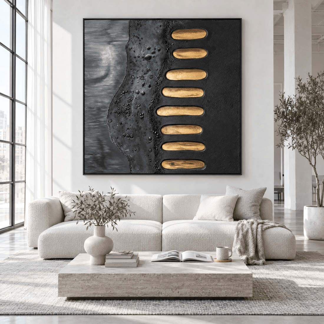 Black and gold minimalist canvas above a cream sofa in a white loft living room