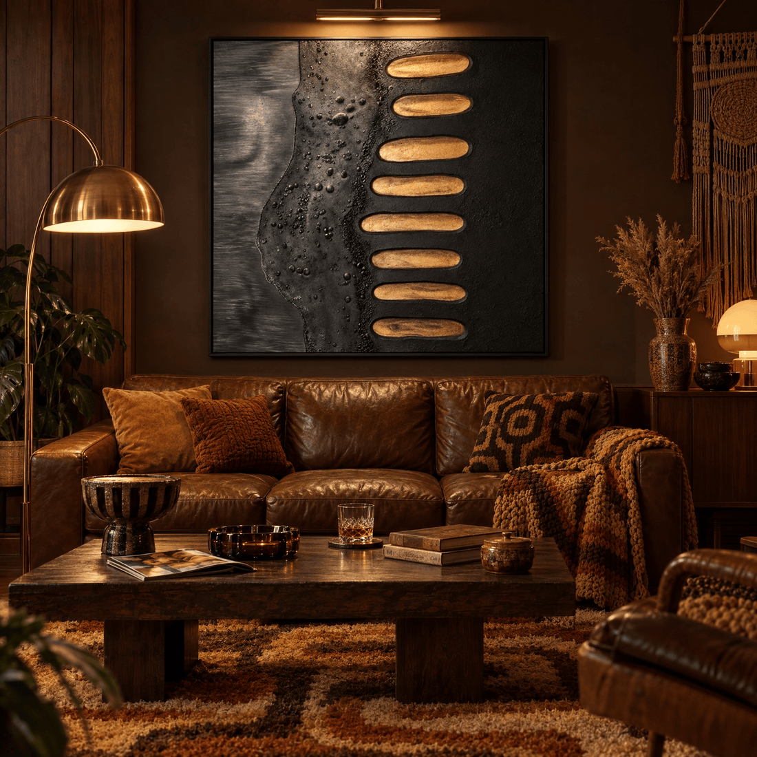 Gold leaf and black textured canvas above a brown leather sofa in a retro seventies den