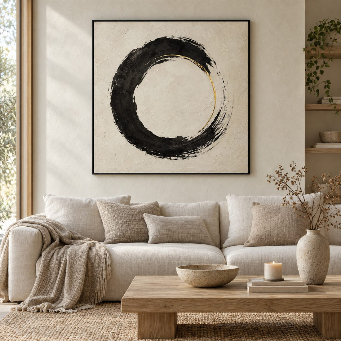 Black enso circle canvas on cream plaster above a linen sofa in a sunlit living room