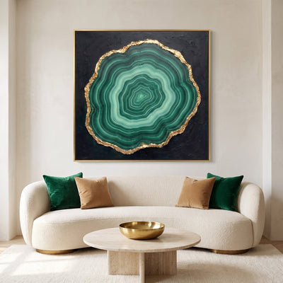 Malachite wall art in emerald green and gold above a cream boucle sofa