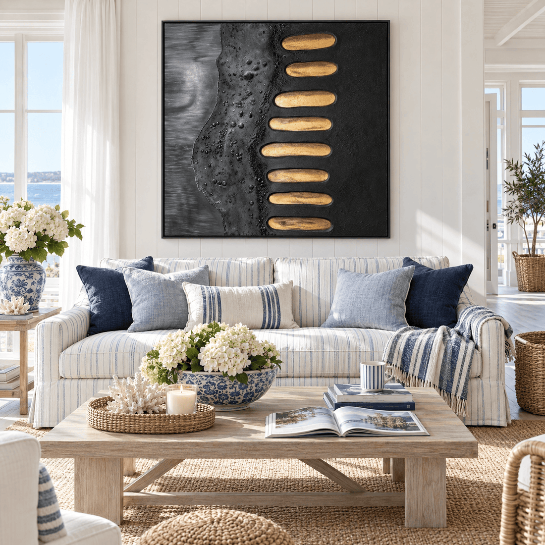 Black and gold wall art above a striped sofa in a coastal Hamptons living room
