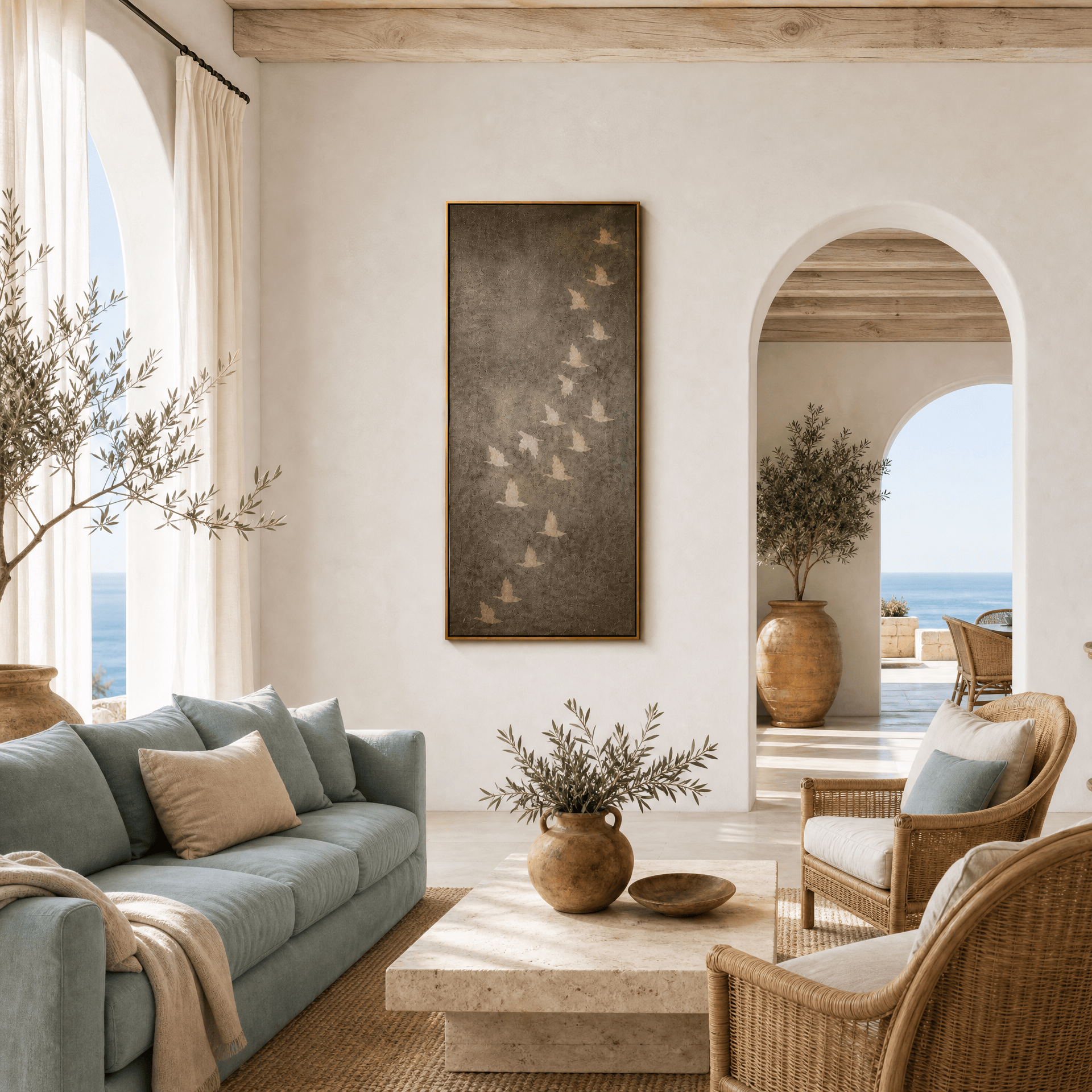 Vertical flying birds wall art in a coastal Mediterranean living room, gold framed charcoal canvas