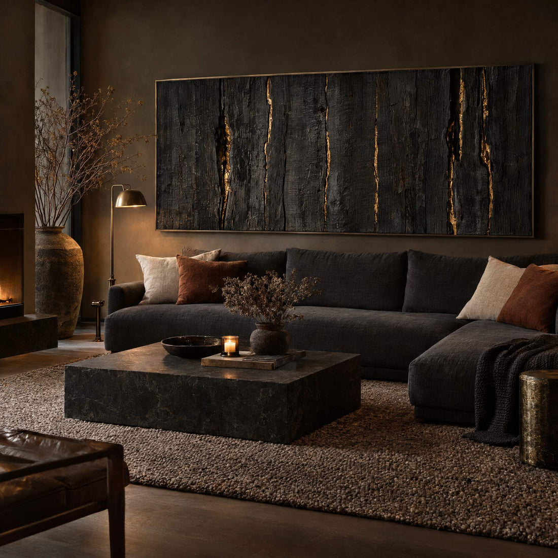Charred timber canvas with gold veins above a charcoal sofa