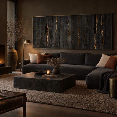 Charred timber canvas with gold veins above a charcoal sofa
