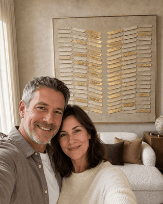 Michelle and David R. at home with their Gilded Reed canvas hanging above the sofa