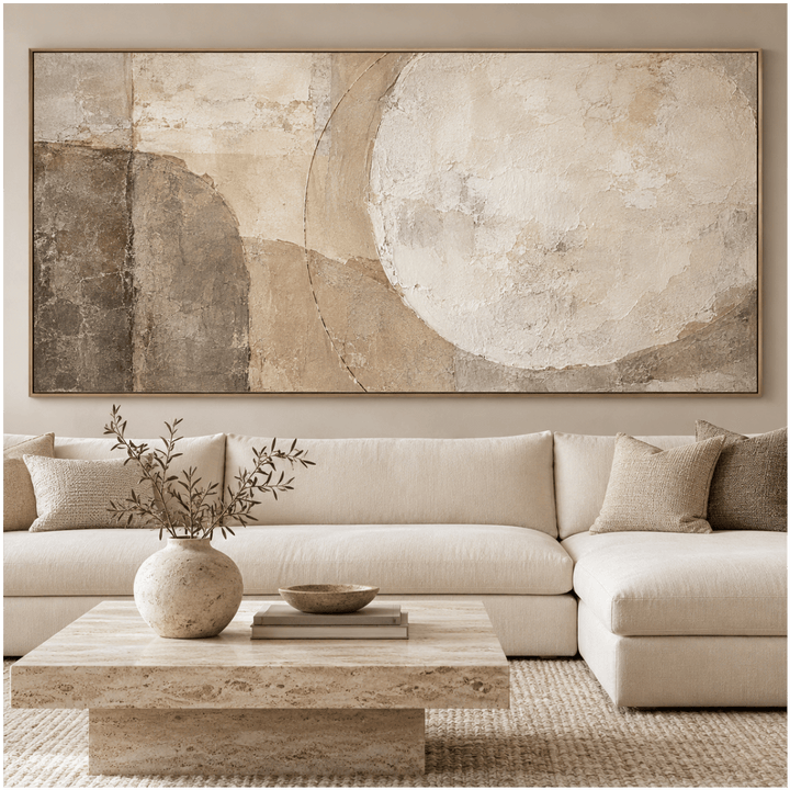 Wabi sabi wall art in beige and taupe above a cream sectional in a neutral living room