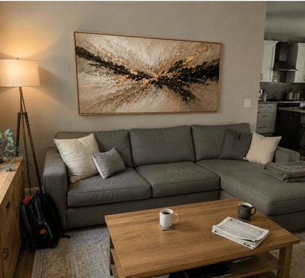 Rebecca T. at home with her Gilded Burst canvas hanging above the sofa