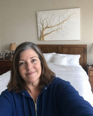 Customer in her bedroom with a white textured branch canvas above the bed