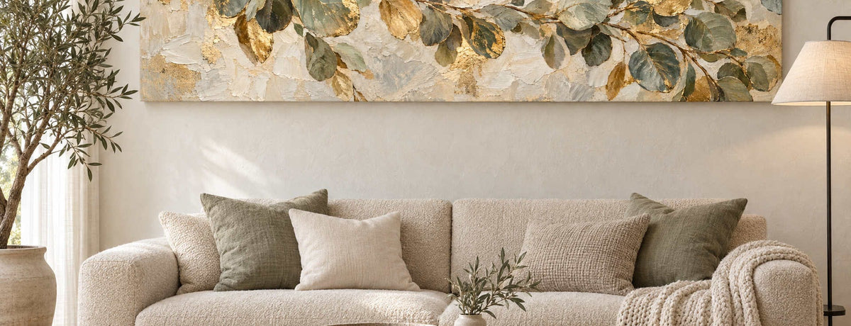 Oversized sage green and gold eucalyptus canvas hung above a cream sofa in a bright living room