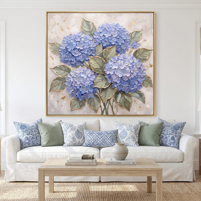 Blue hydrangea wall art with gold leaf above a white slipcovered sofa
