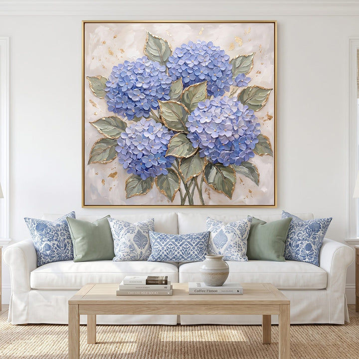 Blue hydrangea wall art with gold leaf above a white slipcovered sofa