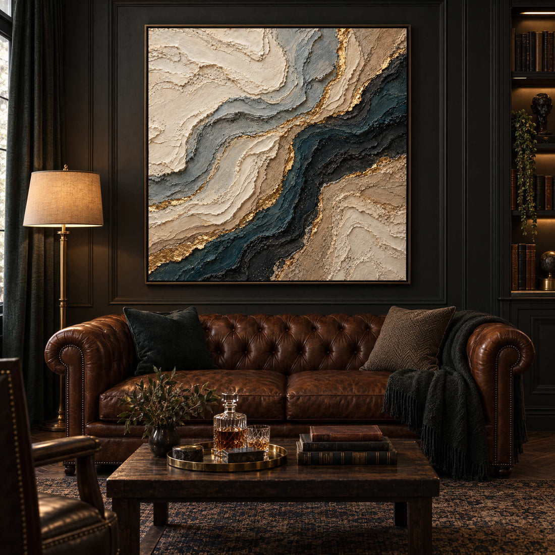 Navy and gold marbled canvas above a leather chesterfield in a dark study