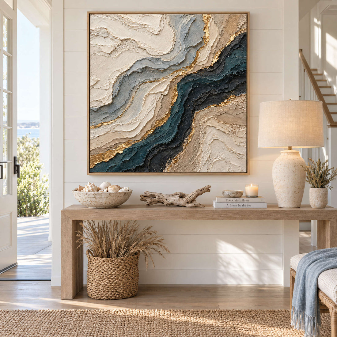 Navy and gold agate canvas above a console in a bright coastal entryway