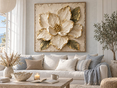 Cream and gold magnolia canvas above a white sofa in a bright coastal living room
