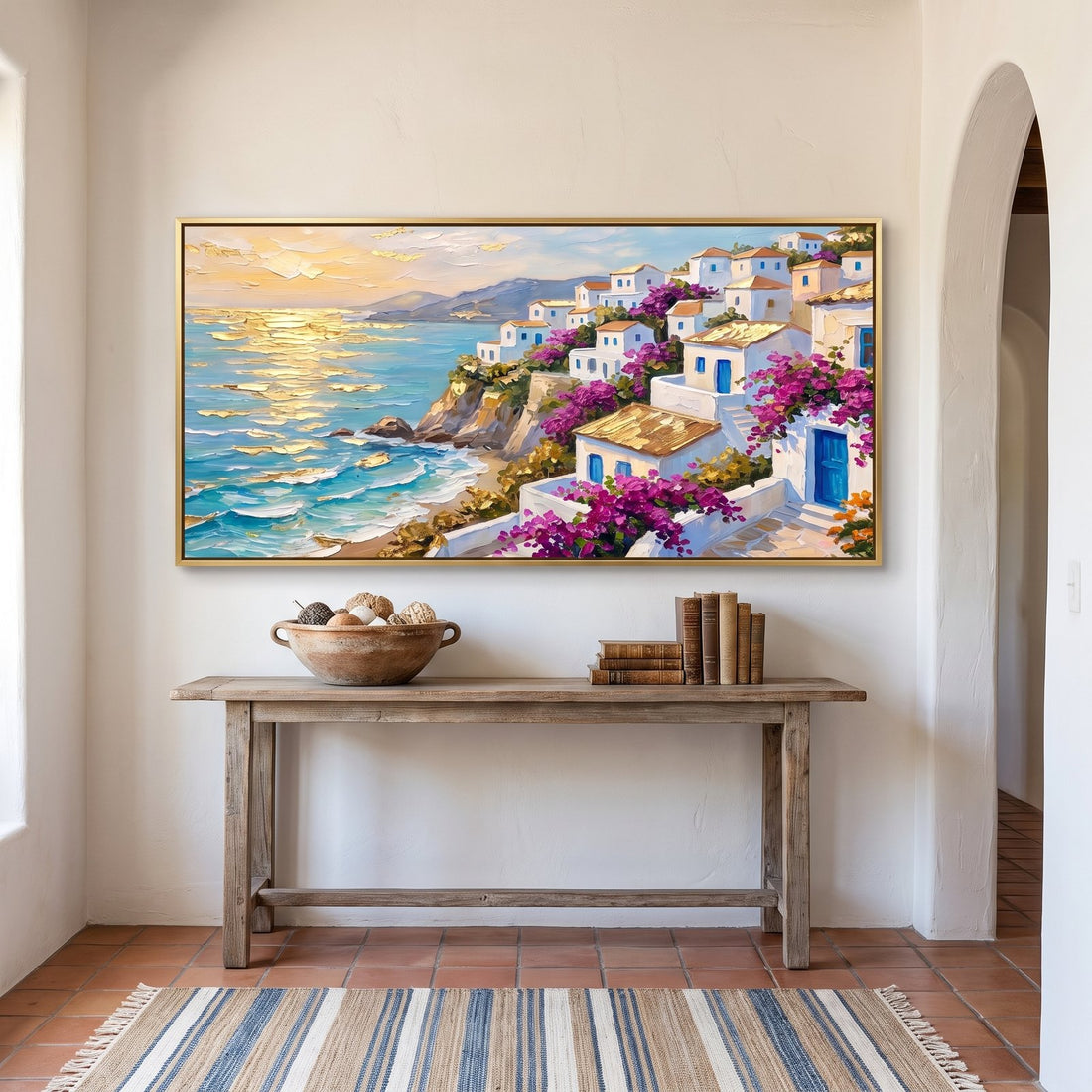 Mediterranean village canvas above a weathered console in a whitewashed hallway