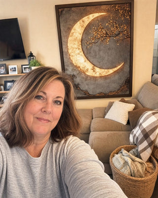 Customer in her living room with the framed Luxury Crescent Moon canvas above the sofa