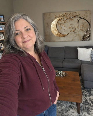 Customer beside a gold crescent moon canvas in her dining room