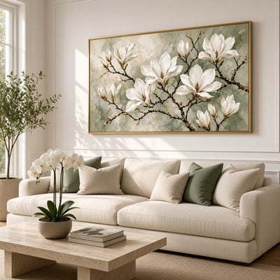 Sage and white magnolia wall art above a sofa