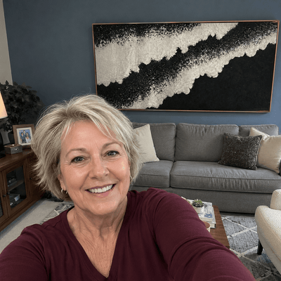 Karen B. at home with her Black Sand Shore canvas hanging above the sofa