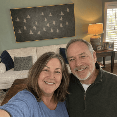 Patricia and David H. at home with their Flying Birds canvas hanging above the sofa