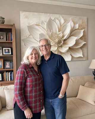 Customer couple in front of a large white and gold floral canvas in their living room